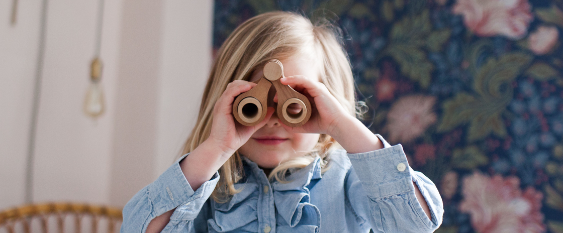 photo enfant avec des jumelles aux yeux